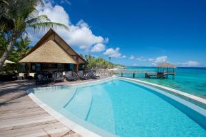 a swimming pool in front of the ocean at Maitai Rangiroa in Avatoru