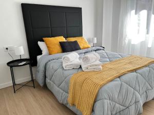 1 dormitorio con 1 cama con toallas en Centro plaza Sardoy, en Murcia