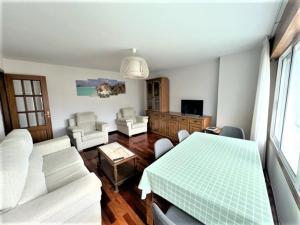 uma sala de estar com uma mesa e um sofá em playa Santa Cristina em Oleiros