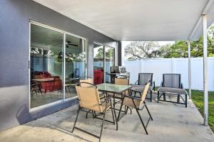 eine Terrasse mit einem Glastisch und Stühlen in der Unterkunft Spacious House Rental 7 Miles to Siesta Key! in Sarasota