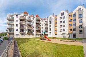 グダニスクにあるApartamenty Sun & Snow Kamienice Nad Motławąのアパートメントビル(前に遊び場あり)