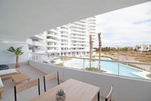 a view from the balcony of a hotel with a table and chairs at Global Properties, Apartamento con terraza y vistas a la piscina en Gran Canet in Canet de Berenguer