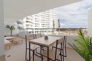 a dining room with a table and chairs and a building at Global Properties, Apartamento con terraza y vistas a la piscina en Gran Canet in Canet de Berenguer