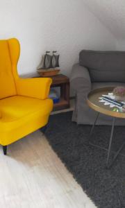 不來梅港的住宿－Ferienwohnung Hafen Rosi，客厅里一张黄色的椅子和一张桌子