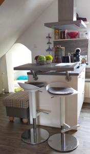 une cuisine avec un comptoir avec deux tabourets dans l'établissement Ferienwohnung Hafen Rosi, à Bremerhaven