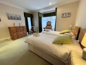 a large bedroom with two beds and a dresser at Pass the Keys Beautiful Period Property in Central Location in Maxwelltown