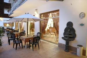 ein Restaurant mit Tischen und Stühlen und einer Uhr an der Wand in der Unterkunft Hotel Arma Ristorante in Arma di Taggia