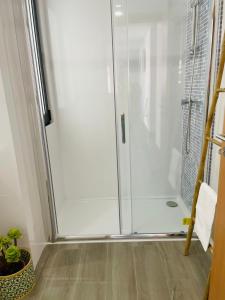 um chuveiro com uma porta de vidro na casa de banho em Porto Smart Apartments Comfort em Perafita