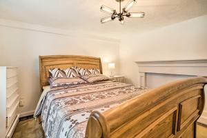sypialnia z drewnianym łóżkiem i żyrandolem w obiekcie Pet-Friendly Apartment in Minneapolis! w mieście Minneapolis