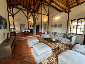 una gran sala de estar con sofás y una mesa. en MILIMA Big 5 Safari Lodge, en Hoedspruit