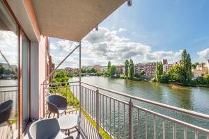 a balcony with chairs and a view of a river at Waterlane Island, Sun & Snow in Gdańsk