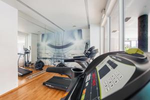 a gym with several treadmills and a treadmill at Apartamenty Sun & Snow Waterlane Island z basenem in Gdańsk
