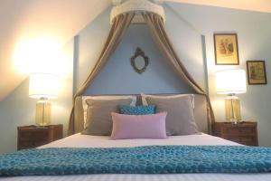a bedroom with a large bed with two lamps at Rosebury Cottage 1 bedroom Free Street parking-5min from Colmar in Wintzenheim