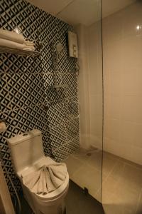 a bathroom with a toilet and a glass shower at Victoria Nimman Hotel in Chiang Mai