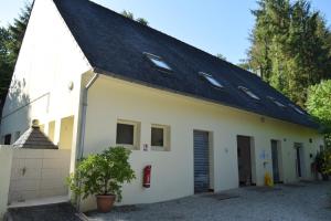 a white building with a black roof at Appartement Privé, Camping La Pointe in Châteaulin
