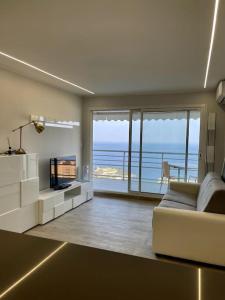 ein Wohnzimmer mit einem Sofa und Meerblick in der Unterkunft Appartamento esclusivo in Monaco in Beausoleil