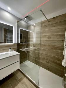 ein Bad mit einer Glasdusche und einem Waschbecken in der Unterkunft Appartamento esclusivo in Monaco in Beausoleil