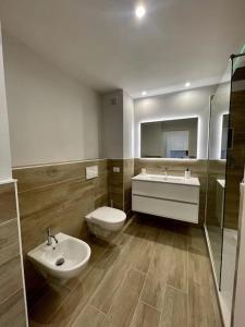 ein Badezimmer mit einem Waschbecken, einem WC und einem Spiegel in der Unterkunft Appartamento esclusivo in Monaco in Beausoleil