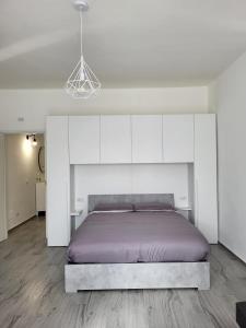 1 dormitorio con 1 cama grande y armarios blancos en Casa al Mare en Bari