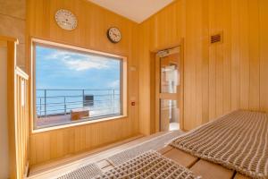 a bedroom with a window with a view of the ocean at Umino Hotel Hajime in Beppu