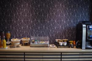 a kitchen with a counter with a purple wall at Logis Hotel Le Chêne Vert in Savenay