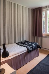 ein Schlafzimmer mit einem Bett mit einer schwarzen und weißen Decke in der Unterkunft Pehtoori 1 Hahkialan Kartanon vierastalon huoneisto in Hämeenlinna