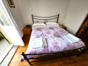 a bedroom with a bed with a pink comforter at Raggio di sole in Levanto