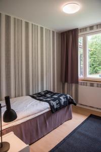 1 dormitorio con cama y ventana en Pehtoori 1 Hahkialan Kartanon vierastalon huoneisto, en Hämeenlinna