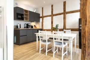 a kitchen and dining room with a white table and chairs at Schiefer Suite Hotel & Apartments in Goslar