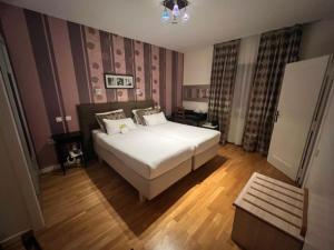 Postel nebo postele na pokoji v ubytování Hotel Le Divona "au coeur de Divonne"