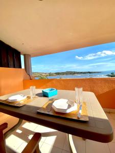 a dining table with a view of the ocean at Residence Porto Coda Cavallo in San Teodoro