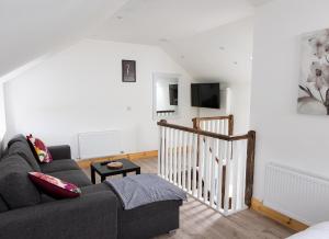 a living room with a couch and a tv at Shannon Castle Holiday Cottages Type A 