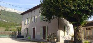 une maison blanche avec un arbre devant dans l'établissement Appartement 1Ch, à Risset