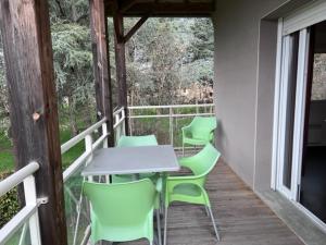 un patio con mesa y sillas en un porche en Les bords de l'Aveyron en Nègrepelisse