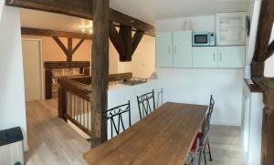 eine Küche mit einem Holztisch und einer Arbeitsplatte in der Unterkunft Chambre avec SDB privative, cuisine et salon partagés 