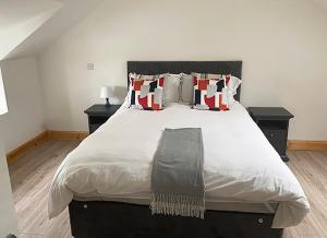 um quarto com uma grande cama branca com almofadas em Shannon Castle Holiday Cottages Type B 