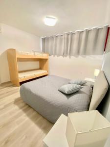 a small bedroom with a bed and a shelf at Premium Apartment Bilo C2 in Marina di Bibbona