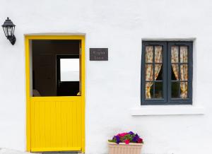 uma porta amarela e uma janela num edifício branco em Shannon Castle Holiday Cottages Type C 