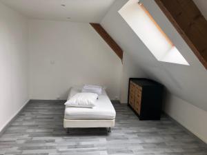 a bedroom with a bed and a dresser in a attic at FENUA : gite 5 chambres 10 couchages en ville in Valognes