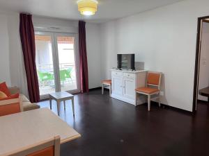 Televízia a/alebo spoločenská miestnosť v ubytovaní Les bords de l'Aveyron