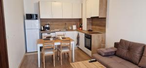 a small kitchen with a table and a couch at Апартамент Тони 1 с панорамна морска гледка и паркинг Варна in Varna City