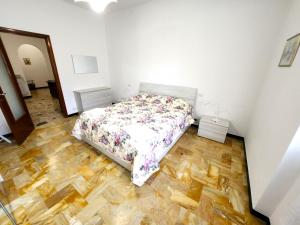 Un dormitorio con una cama y suelo de madera. en Appartamento Gambero Rosso, en Levanto