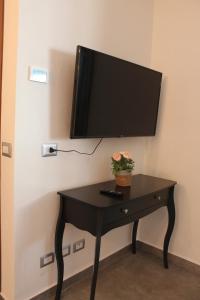 une table noire avec une télévision sur un mur dans l'établissement Casa PG, à Stresa