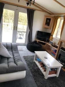 a living room with a couch and a coffee table at Woodland Lodge With Hot Tub in Malton