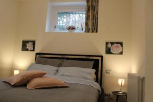 - une chambre avec un lit avec deux oreillers et une fenêtre dans l'établissement Casa PG, à Stresa