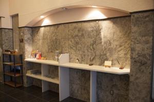 a counter in a room with a stone wall at Business Inn Norte 2 in Sapporo