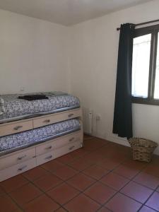 1 dormitorio con cama, ventana y suelo de baldosa en La Rotiza, en La Collada