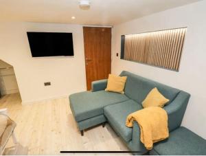 a living room with a green couch and a television at Studio @ Southcliff in Scarborough