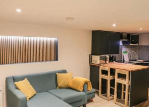 a living room with a blue couch and a kitchen at Studio @ Southcliff in Scarborough