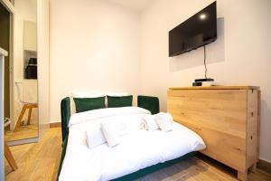 - une chambre avec un lit et une télévision à écran plat dans l'établissement Cosy studio on bastille, à Paris